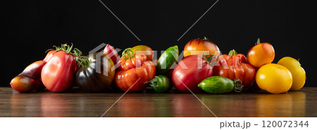 Different varieties of tomatoes on a wooden table. Different varieties of tomatoes on a wooden table. 120072344