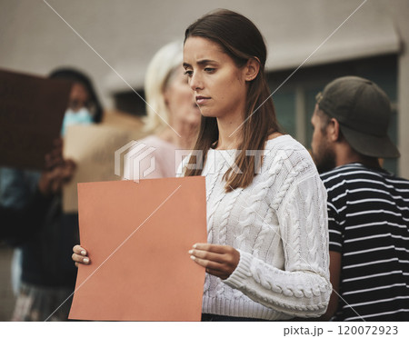 Do not be dismayed. Cropped shot of an attractive young woman holding a sign while protesting for her rights. Do not be dismayed. Cropped shot of an attractive young woman holding a sign while protesting for her rights. 120072923