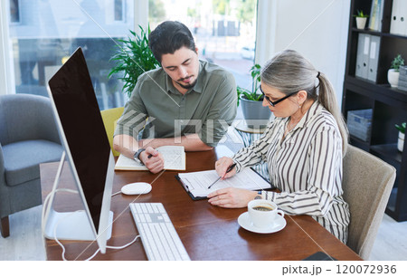 They have a lot to get through today. Shot of two businesspeople going through paperwork together in an office. 120072936