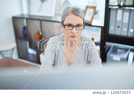 Focused on her deadlines. Shot of a mature businesswoman working on a computer in an office. 120073033