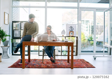 Figuring out some new plans. Shot of two businesspeople working together on a laptop in an office. Figuring out some new plans. Shot of two businesspeople working together on a laptop in an office. 120073162