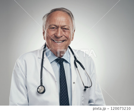 making my way through the hospital. Shot of a happy elderly male doctor in the studio against a grey background. 120073210