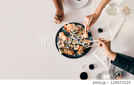 Above, sushi or hands of people with chopsticks for lunch, luxury meal or takeaway food in office. Japanese cuisine, utensils or women at table for sharing, high quality catering or business expense 120073524