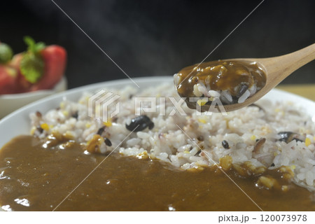 湯気の立つ雑穀とカレーをスプーンですくう 120073978