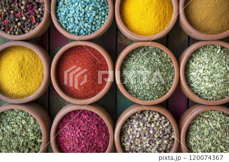 A vibrant collection of spices in earthenware bowls. 120074367