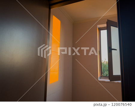 Sunset Light Streaming Through an Open Window in a Cozy Room Showcasing Warm Colors and a Serene Atmosphere During the Evening 120076540