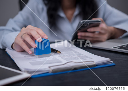 woman hand stamping a document, signifying approval or verification in an office setting. Ideal for legal, business, or administrative woman hand stamping a document, signifying approval or verification in an office setting. Ideal for legal, business, or administrative 120076566