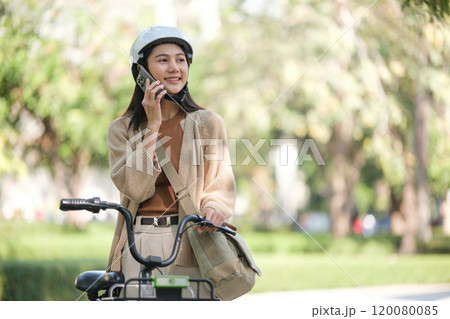 A woman is talking on her cell phone while riding a bicycle 120080085
