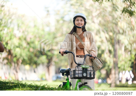 A woman is riding a bicycle in a park A woman is riding a bicycle in a park 120080097