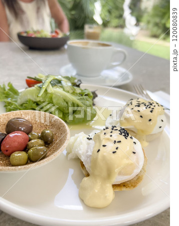 poached eggs, olive and green salad on table for breakfast poached eggs, olive and green salad on table for breakfast 120080839