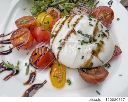 burrata cheese salad with tomatoes on white plate burrata cheese salad with tomatoes on white plate 120080867