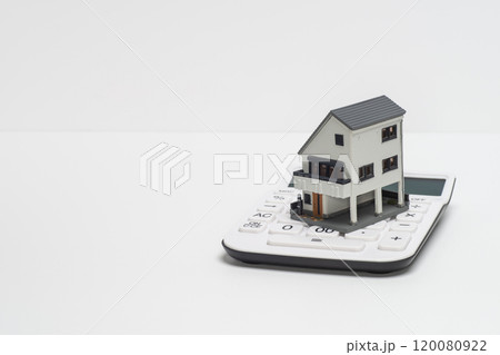 電卓と戸建て住宅の模型で住宅ローンのイメージ 電卓と戸建て住宅の模型で住宅ローンのイメージ 120080922