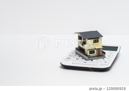 電卓と戸建て住宅の模型で住宅ローンのイメージ 電卓と戸建て住宅の模型で住宅ローンのイメージ 120080928