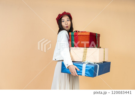 Young Asian Woman with Stack of Holiday Gifts Expressing Surprise and Joy During Christmas Season Shopping Experience in Studio Perfect for Seasonal Marketing Young Asian Woman with Stack of Holiday Gifts Expressing Surprise and Joy During Christmas Season Shopping Experience in Studio Perfect for Seasonal Marketing 120083441