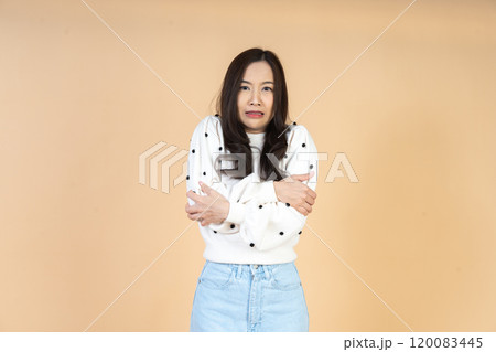 Stylish Model Showing Seasonal Discomfort and Shivering in Contemporary Casual Outfit Captured in Minimal Studio Setting Ideal for Lifestyle Content 120083445