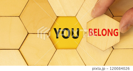 Belonging and you belong symbol. Concept words You belong on beautiful wooden puzzle. Beautiful wooden background. Businessman hand. Business belonging and you belong concept. Copy space. 120084026