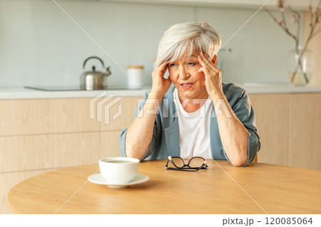 Headache pain. Unhappy middle aged senior woman suffering from headache sick rubbing temples at home. Mature old senior grandmother touching temples experiencing stress Woman feeling pain hurt in head Headache pain. Unhappy middle aged senior woman suffering from headache sick rubbing temples at home. Mature old senior grandmother touching temples experiencing stress Woman feeling pain hurt in head 120085064