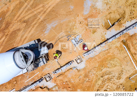 Preparation of construction site is concrete mixer truck is laying concrete along prefabricated foundation forms 120085722
