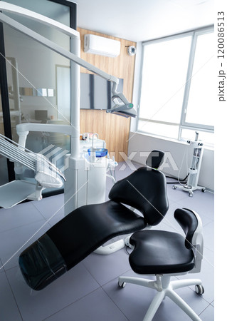 Dental equipment in empty dentist office in new modern clinic room, dental chair and accessories 120086513