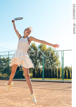 Young female tennis player looking confident and determined on the courts 120086581