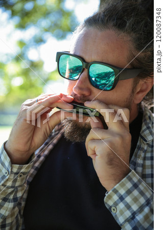 Man Wearing Sunglasses Playing Harmonica, Mouth Organ Man Wearing Sunglasses Playing Harmonica, Mouth Organ 120087348