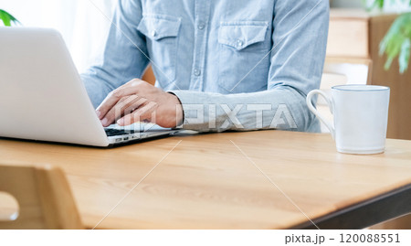 リビングでパソコンを使う男性 120088551