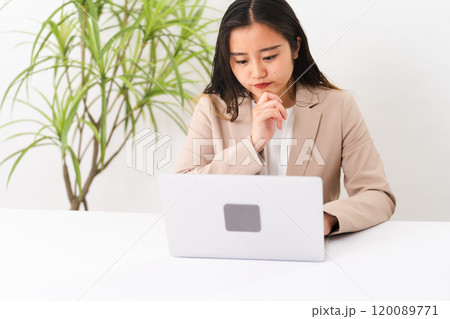 ビジネススーツを着てラップトップを操作している若い女性　ビジネスイメージ 120089771