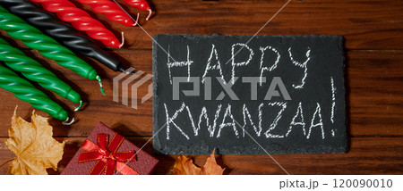 Kwanzaa African American holiday. Seven candles red, black and green on natural wooden background. Kwanzaa African American holiday. Seven candles red, black and green on natural wooden background. 120090010