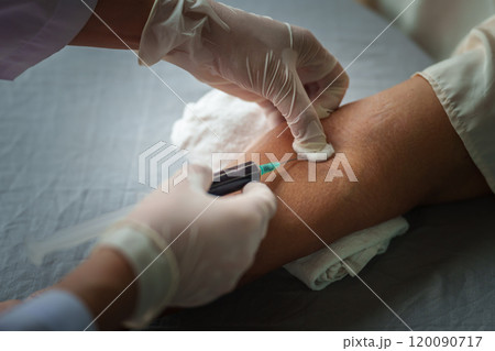 Close up of doctor or nurse taking a blood sample from arm vein with vacutainer. syringe to venipuncture the patient Close up of doctor or nurse taking a blood sample from arm vein with vacutainer. syringe to venipuncture the patient 120090717
