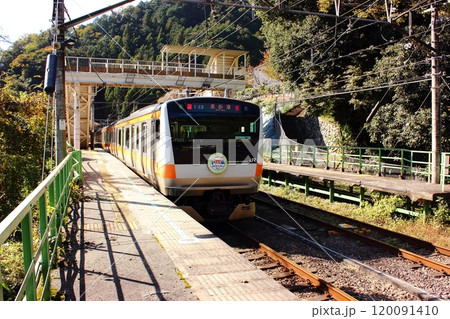 明るい陽射しを浴びながら青梅線の鳩ノ巣駅を発車した奥多摩行電車（2） 120091410