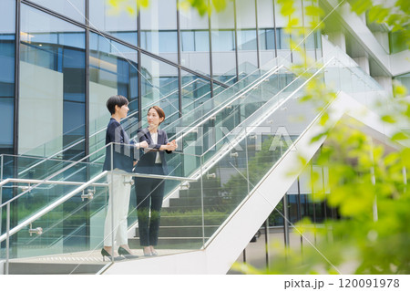 オフィスの前で立ち話をする2人の女性 オフィスの前で立ち話をする2人の女性 120091978