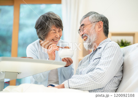 旦那に食事を与えるシニア女性 旦那に食事を与えるシニア女性 120092108
