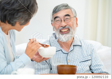 旦那に食事を与えるシニア女性 120092110