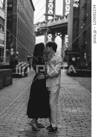 A couple passionately embracing each other in the vibrant urban landscape of the city A couple passionately embracing each other in the vibrant urban landscape of the city 120092234