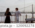 A Loving and Intimate Couple Embraces Tenderly with a Stunning Iconic Bridge in the Background 120092278