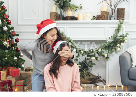 Two Women siblings using hands decorate Christmas tree red ball, bauble, snow flake. Close up hands holding red ball bauble decorate. Asian woman friends decor bauble ball christmas tree xmas holiday 120092509