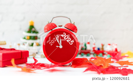 Happy New Year writing on paper note.  2024 and 2025 on red alarm clock on Christmas item. 120092681