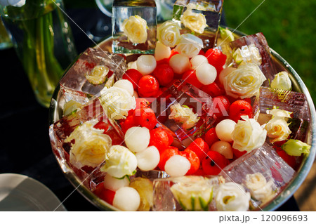 A bowl of ice cubes with frozen flowers and berries. A bowl of ice cubes with frozen flowers and berries. 120096693