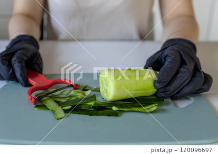 Woman peeling cucumber, closeup. Hands peeling cucumber close up Woman peeling cucumber, closeup. Hands peeling cucumber close up 120096697