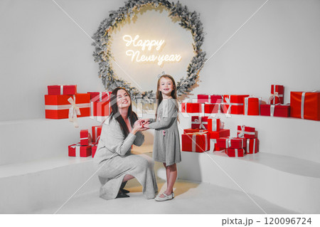 happy mom and daughter with red gift box in christmas decor. 120096724