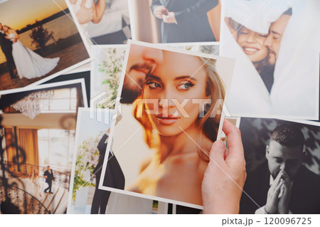 women's hands put on the table and show wedding photos. 120096725