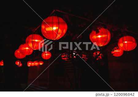 Glowing red traditional paper Chinese lanterns decorate the facade of building in Asia at night Glowing red traditional paper Chinese lanterns decorate the facade of building in Asia at night 120096842