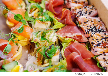 A box with an assortment of meat and fish appetizers for the buffet table. A box with an assortment of meat and fish appetizers for the buffet table. 120096978