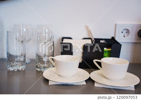 two empty white tea or coffee cups on a table in the hotel room. two empty white tea or coffee cups on a table in the hotel room. 120097053