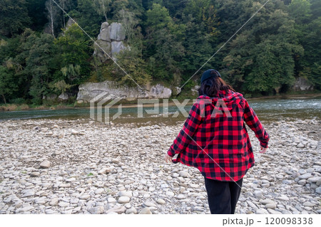 Woman smiling and walking on a rocky riverbank Woman smiling and walking on a rocky riverbank 120098338