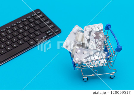 Ordering Medicines. Pills and Capsules in a Shopping Cart on Blue Background Ordering Medicines. Pills and Capsules in a Shopping Cart on Blue Background 120099517