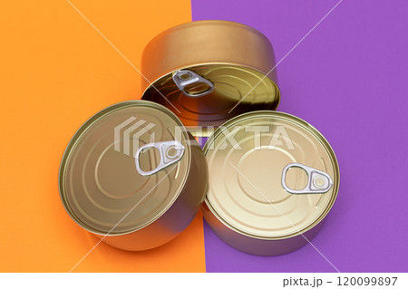 A Group of Stacked Tin Cans with Blank Edges on Split Orange and Violet Background A Group of Stacked Tin Cans with Blank Edges on Split Orange and Violet Background 120099897