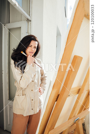 Female artist painting paintings with paints on canvas with easel Female artist painting paintings with paints on canvas with easel 120100033