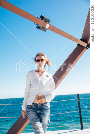Beautiful woman of 40 years old walking on the beach by the sea 120100036
