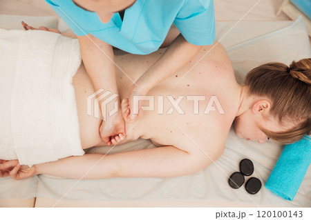chiropractor giving medical facial massage to woman in spa chiropractor giving medical facial massage to woman in spa 120100143